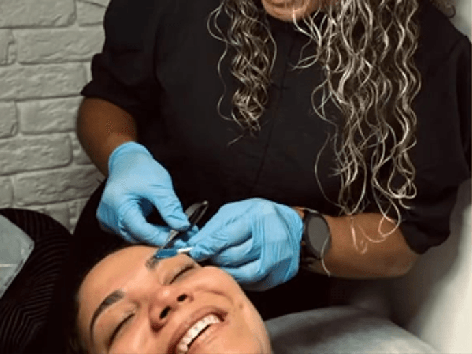 Profissional aplicando extensão de cílios em cliente no Studio Geizi Silva
